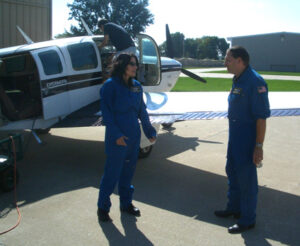Greg (back to camera) performs pre-flight preparations as Tom warns me of the dangers of air sickness.